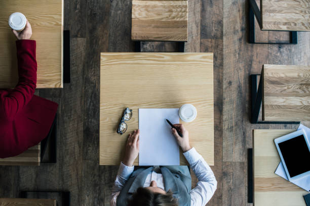 istock businesswoman writing document in cafe 893517294