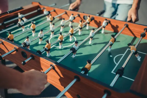 cropped shot of people playing table football outdoors