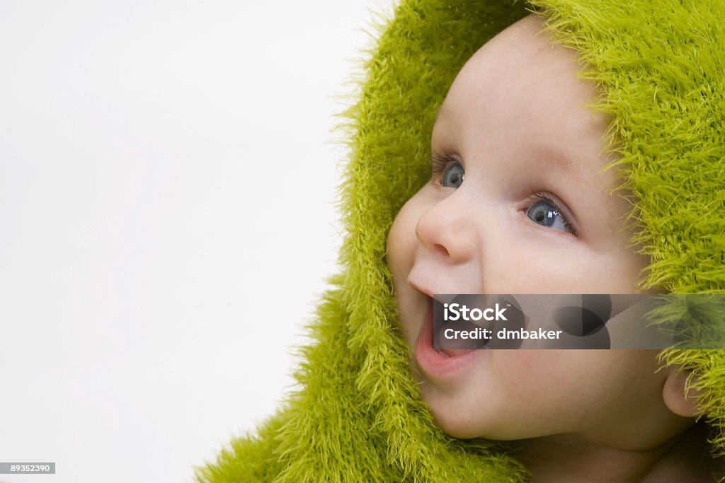 Cute Smiling Happy Beautiful Baby Wrapped In A Green Blanket A beautiful smiling baby wrapped in a furry green blanket Baby - Human Age Stock Photo