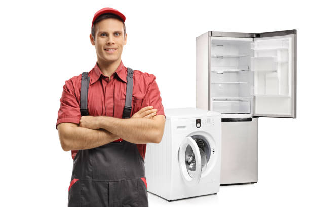 洗濯機と冷蔵庫の前で腕組みして修理 - appliance repairing clothes washer refrigerator ストックフォトと画像