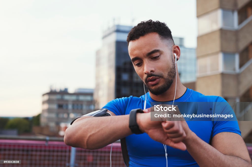 Männliche Läufer verwendet app auf Smartwatch in städtischen Straße, Nahaufnahme - Lizenzfrei Fitnesstraining Stock-Foto