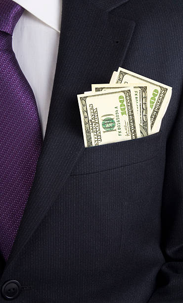 Businessman with dollars in his jacket pocket stock photo