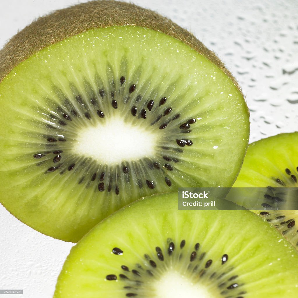 fresh sliced kiwi fruits studio shot showing a arrangement of fresh sliced kiwi fruits in wet ambiance Close-up Stock Photo