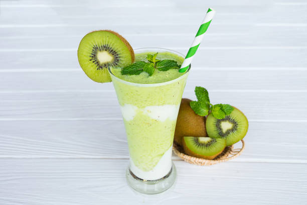 Kiwi Yogurt Healthy Fruit Smoothie Drink in the morning on a white wood background.