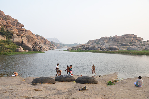 Hampi, Karnataka, India- December 2, 2017:  Religious people doing morning ritual  at the Ghats of Tungabadra River