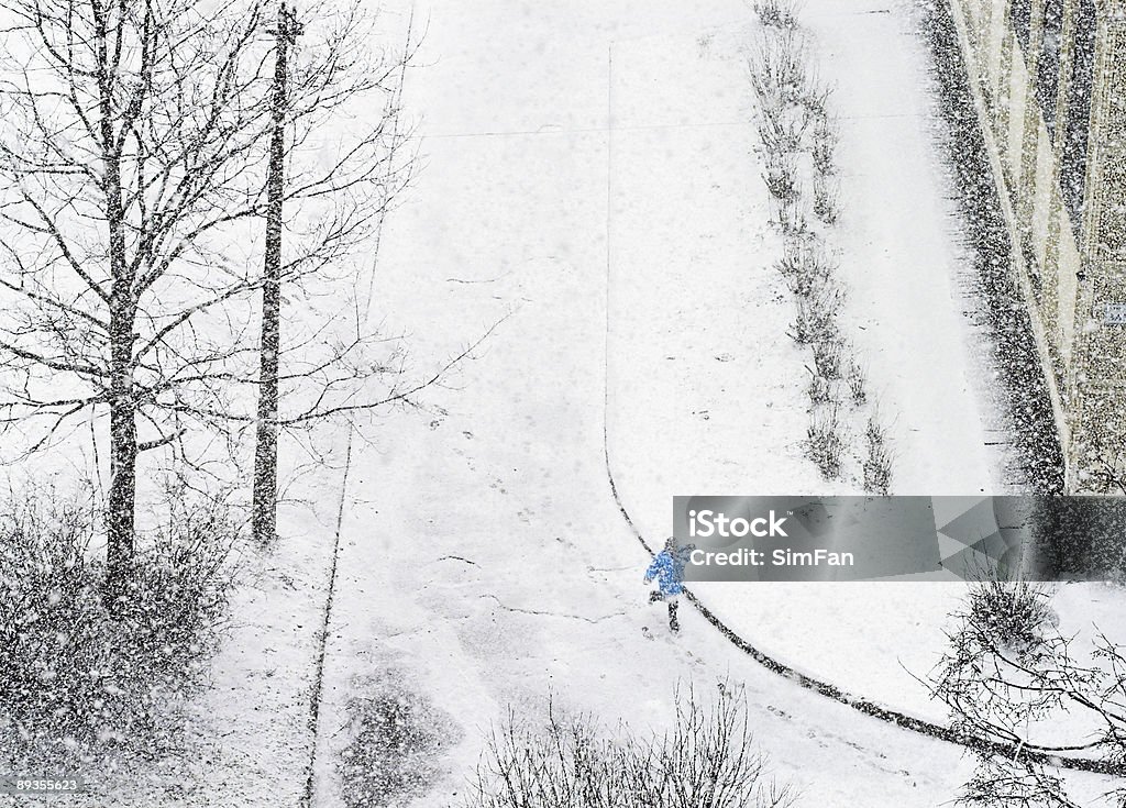 Garota correndo na estrada enquanto snowfalling - Foto de stock de Abandonado royalty-free