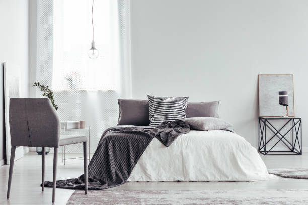 istock Grey chair in white bedroom 893560654