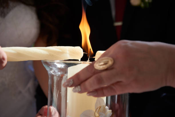 istock Close up groom and bride light wedding candles 893561584