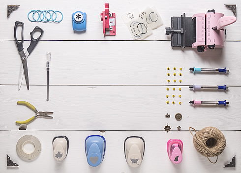 top view of wooden table with tools for scrapbooking and copy space