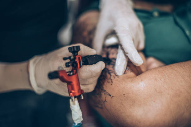 istock Tattoo artist doing his job 893573416