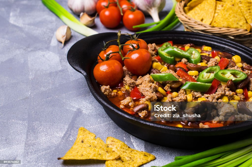 Traditional Mexican chili concarne Traditional Mexican chili con carne on the table with vegetables and nachos. Selective focus. Chile Stock Photo