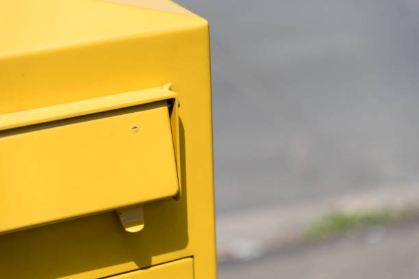 A yellow mailbox on a street