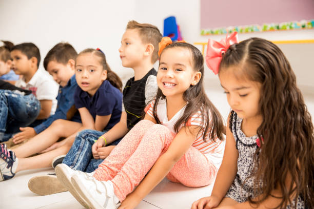 istock Preschool kids sitting on the classroom floor 893587720