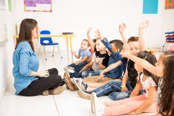 istock Preschool students raising their hands 893590098