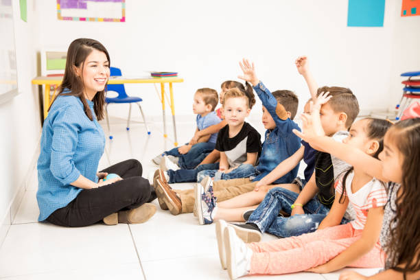 istock Teacher and students having fun at school 893590512