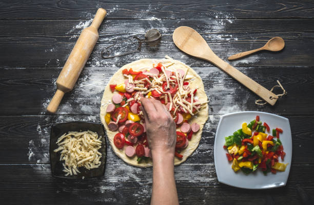 mão de mulher estabelece os ingredientes na pizza - pizza sauces chef making - fotografias e filmes do acervo