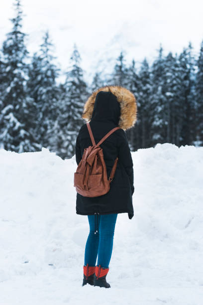 istock Young female giving back in a snow way 893593890