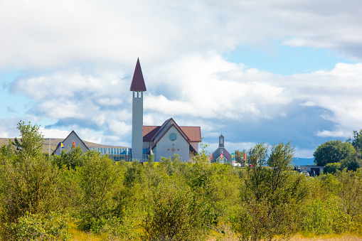 An old wooden church with blue domes in the hilly expanses of Cherdyn (Russia). The textured cloudy sky serves as a great backdrop. An ancient small town on 7 hills in the Northern Urals