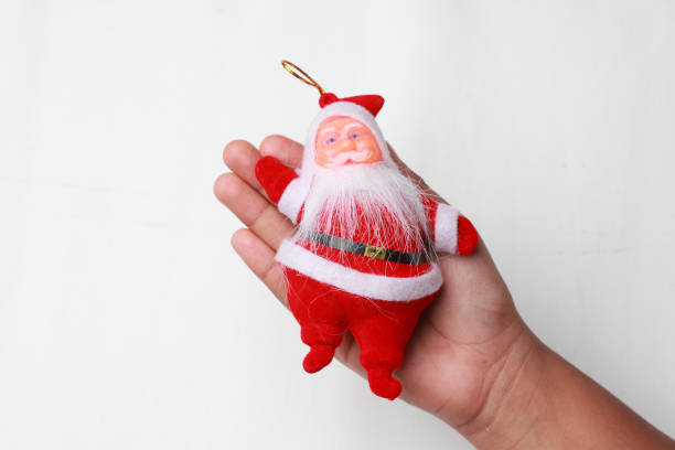 istock Santa dolls on a Child's hand against white background 893604420