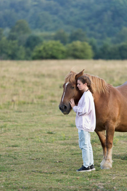 istock Teenager with Horses in a meadow 893629272