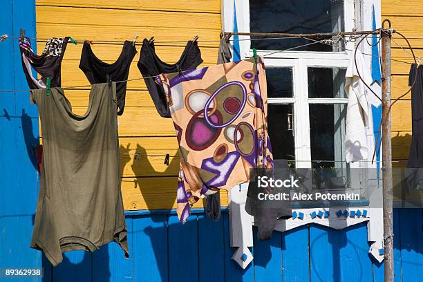 Foto de Linho Secagem Em Um Cabo Do Lado De Fora De Uma Casa Amarela e mais fotos de stock de Aldeia