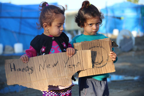 refugee camp syria - little girls showing paper - happy new year camp refugee, 2018, playing kids, syria, syrian kids syria photos stock pictures, royalty-free photos & images