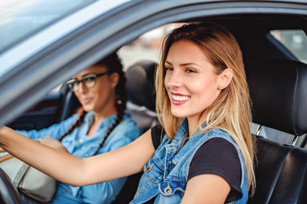 istock Two girlfriends driving in the car and smiling 893663312