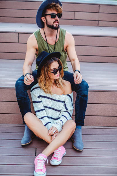 istock Hipster couple sitting on the stairs looking serious 893663376