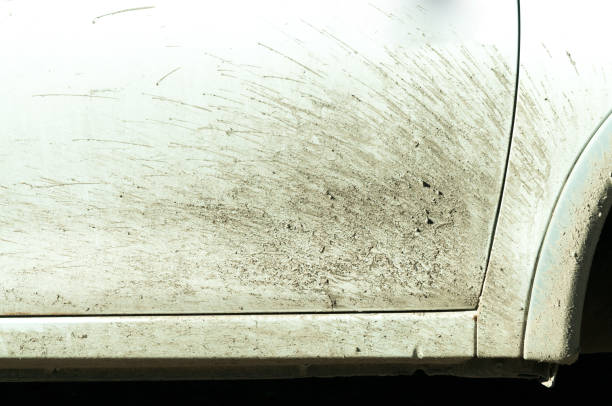 istock Dirty white car with dust and dirt from driving through water and mud after rain 893673050