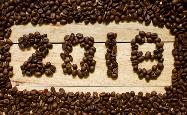 istock 2018 coffee bean text on wood background, new year concept 893673110