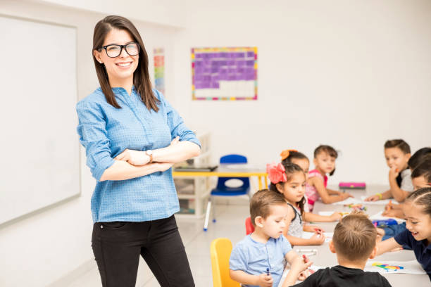 istock Preschool teacher with her students 893685290