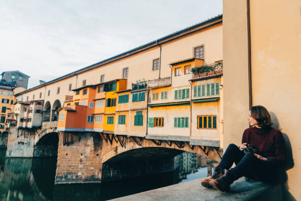 istock Woman looking at the river Arno in Florence 893686950