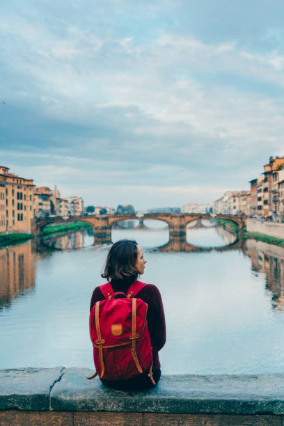 istock Woman sitting on Ponte Veccio and looking at view 893687600