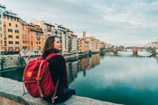 istock Woman sitting on Ponte Veccio and looking at view 893687670