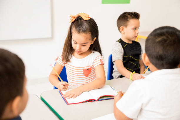 istock Hispanic preschool girl working in class 893689924