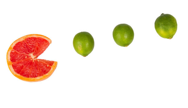 Sliced orange with small limes chase like pac man stock photo