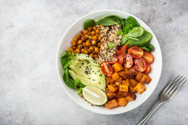 ciotola per il pranzo vegano healhty. insalata di avocado, quinoa, patate dolci, pomodoro, spinaci e ceci - roasted sesame seeds foto e immagini stock