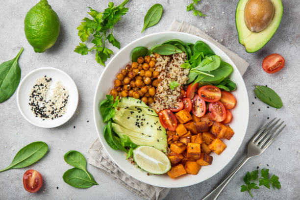 healhty vegan lunch bowl. Avocado, quinoa, sweet potato, tomato, spinach and chickpeas vegetables salad healhty vegan lunch bowl with ingredients. Avocado, quinoa, sweet potato, tomato, spinach and chickpeas vegetables salad. Top view vegan stock pictures, royalty-free photos & images