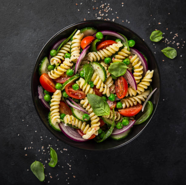 istock pasta salad with tomato, cucumber, spinach and grean peas 893756618