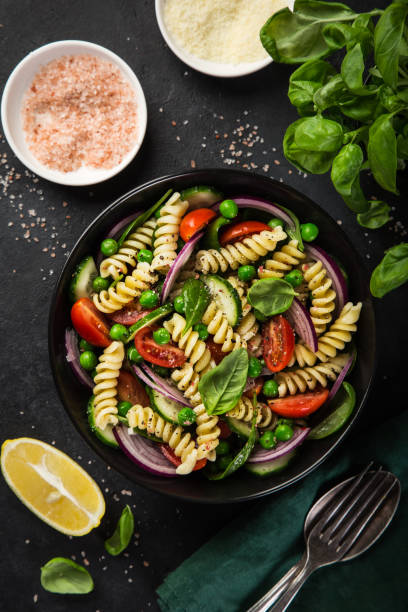 istock pasta salad with tomato, cucumber, spinach and grean peas 893756648