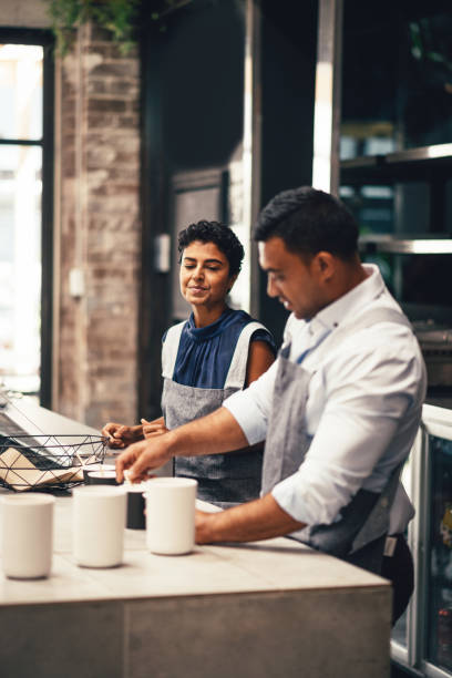 istock Baristas in modern cafe working together and making coffees 893806102