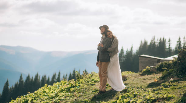 istock Newlyweds stand, smile and hug in mountains. 893852348