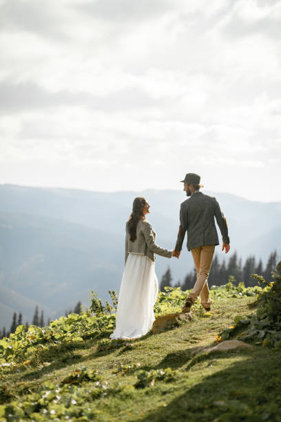 istock Newlyweds walk and hold hands in mountains. 893852484