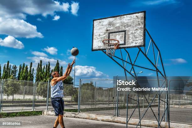 Lefty Jump Shot In A Playground On A Cloudy Day Stock Photo - Download Image Now - 30-39 Years, Acrobatic Activity, Active Lifestyle