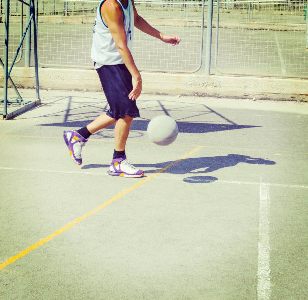 istock Basketball player dribbling in a playground 893890930