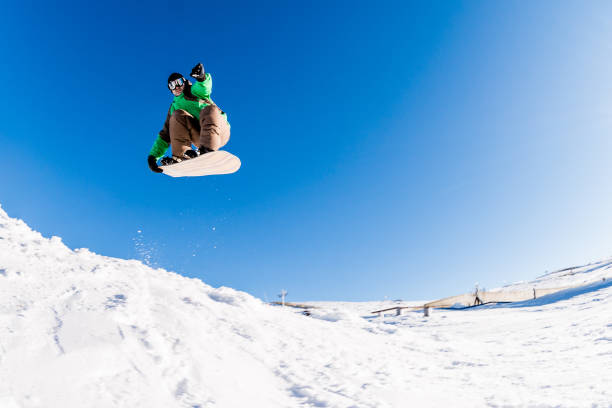 istock Snowboarder jumping against blue sky 893942610