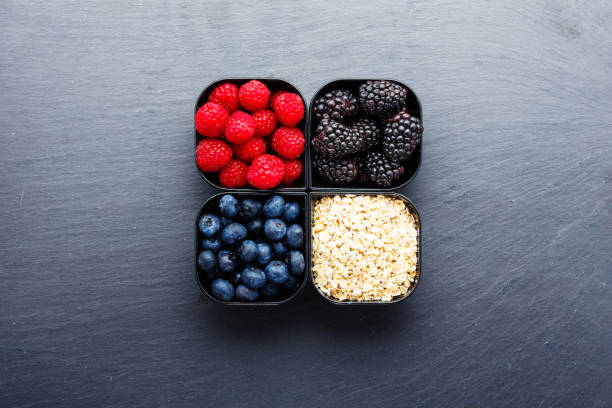 istock Raspberries blueberries blackberries and wholewheat oats in small cups 893945118