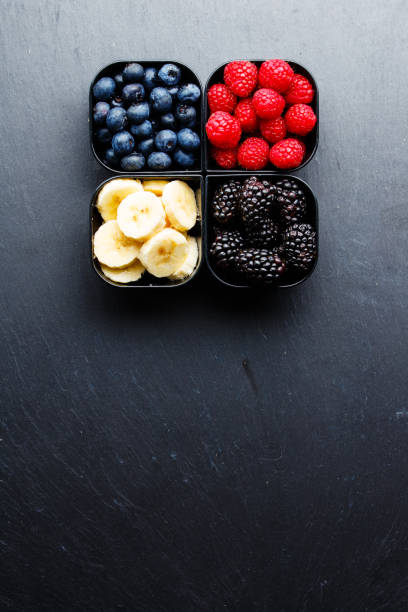 istock Fresh organic berries and banana slices in plastic cups 893949114