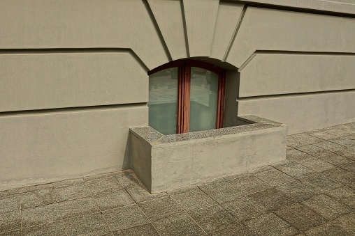 A small window on the lower tazhe gray house by the sidewalk