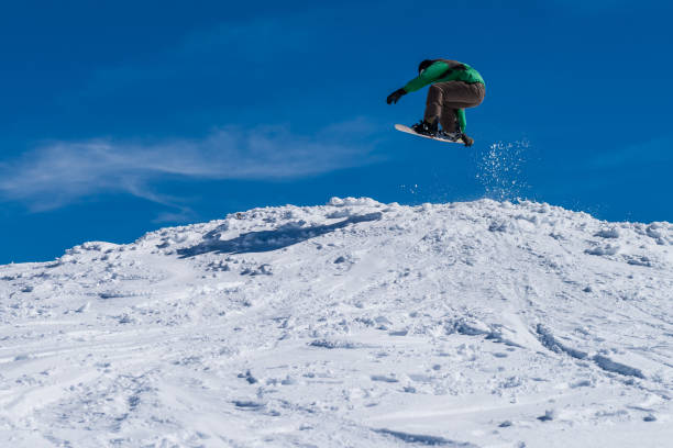 istock Snowboarder jumping against blue sky 893959684